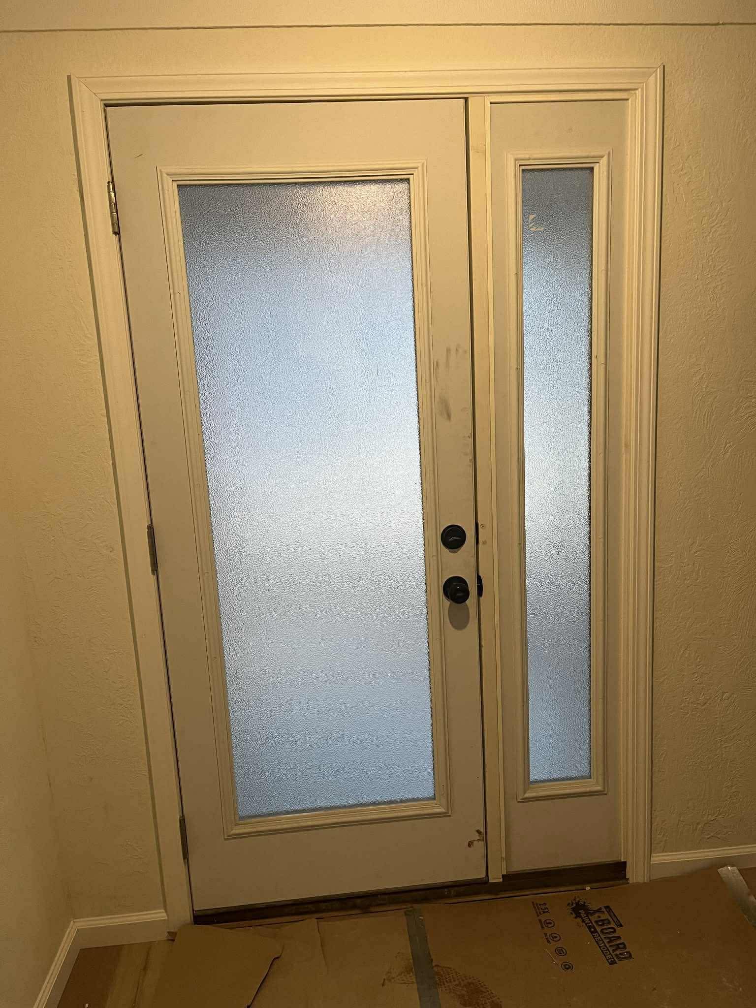 Frosted glass entry door with sidelight panel installation by Frame to Finish Construction