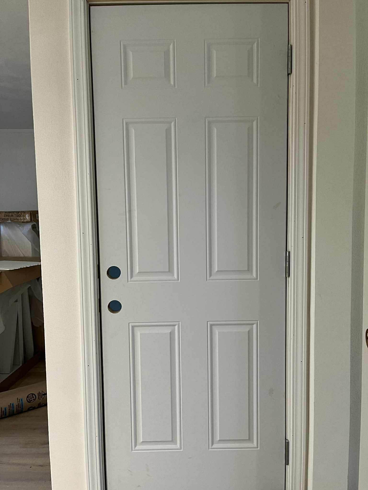 White six-panel interior door with professional trim and hardware