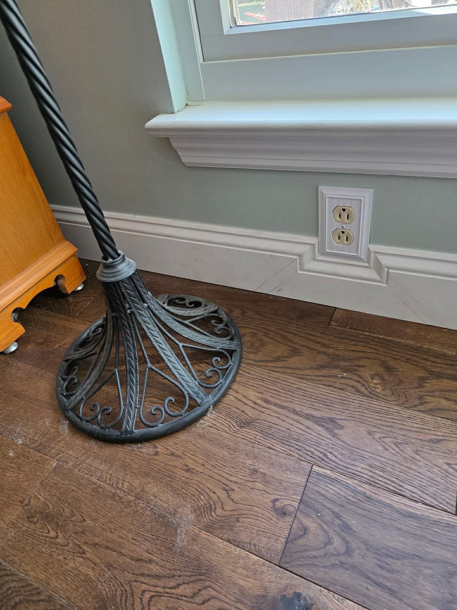 Dark hardwood flooring with white baseboard and custom window trim detail