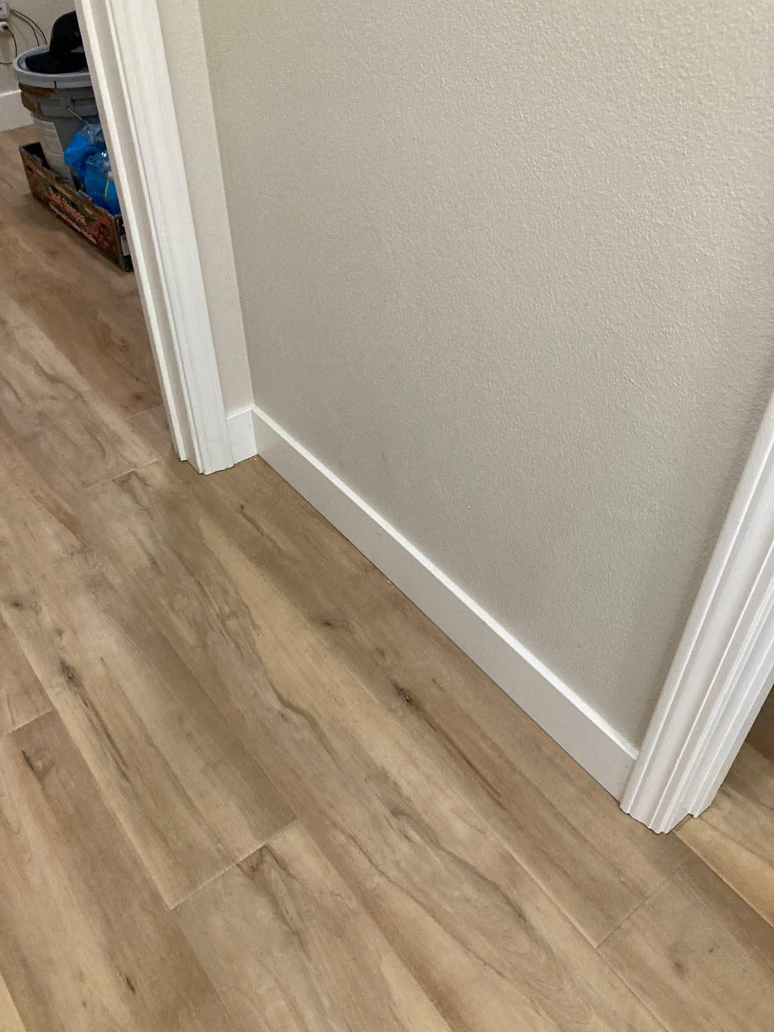 LVP flooring showing precise door casing and baseboard trim detail work
