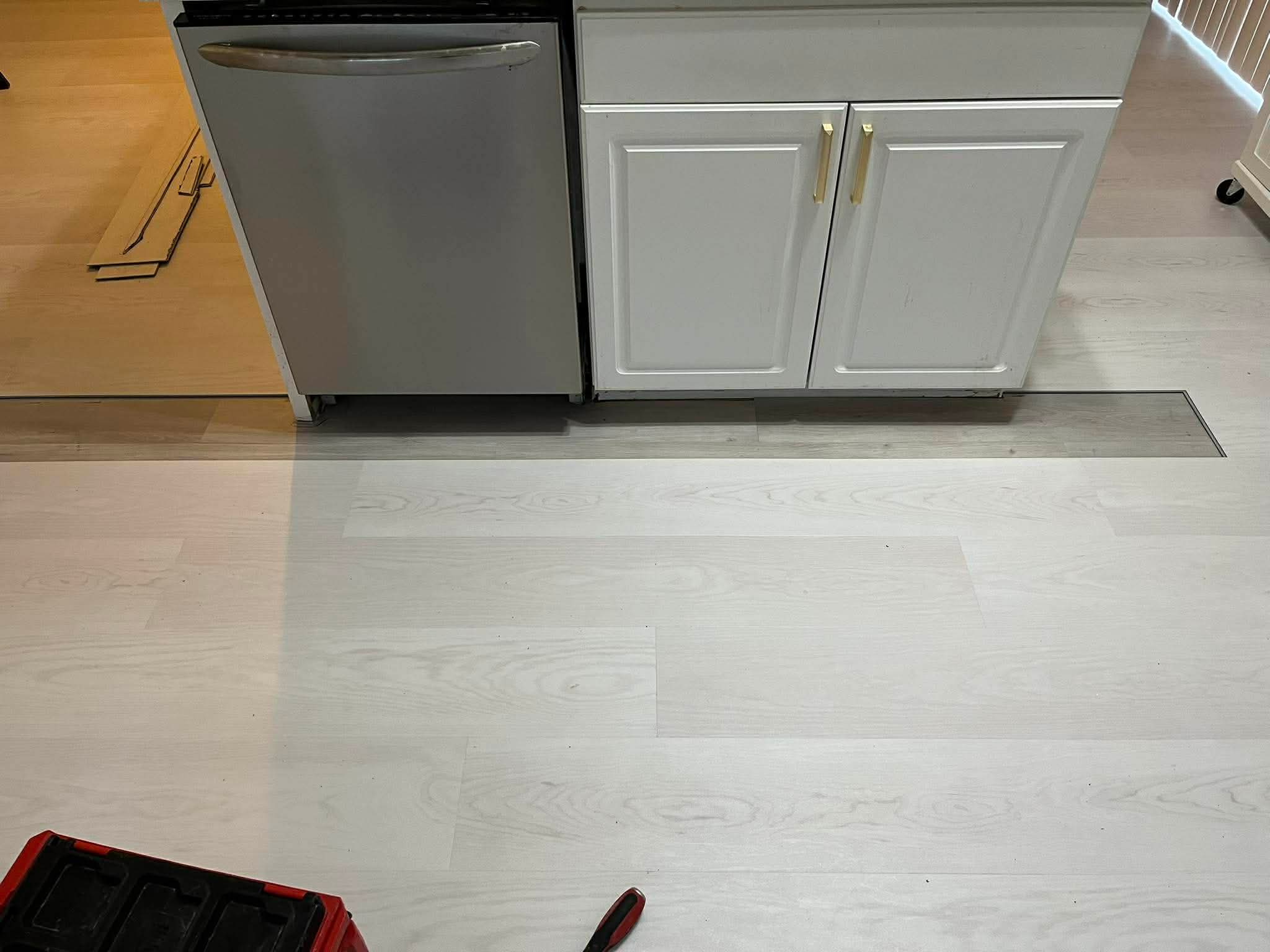 Kitchen with luxury vinyl plank flooring, white cabinets, and stainless steel appliances